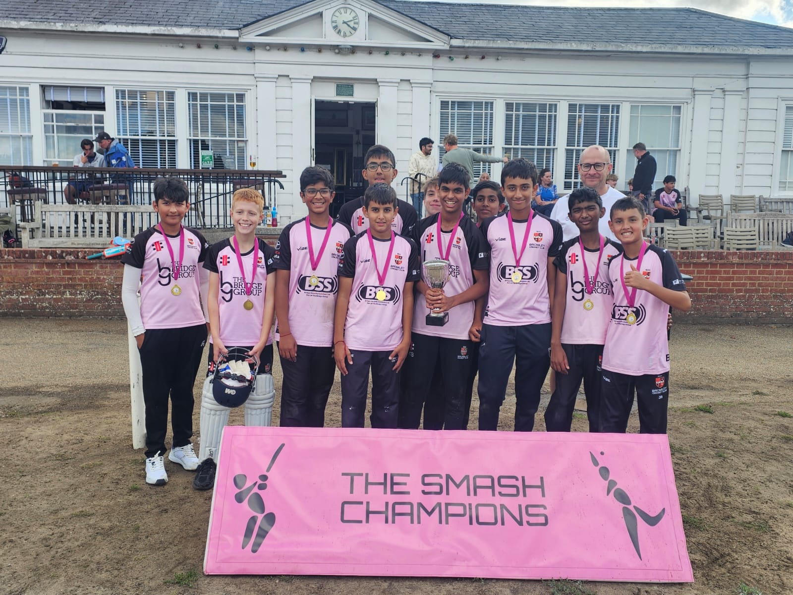 Bromley U12 Hornets with their trophy, medals and Smash Champions banner.